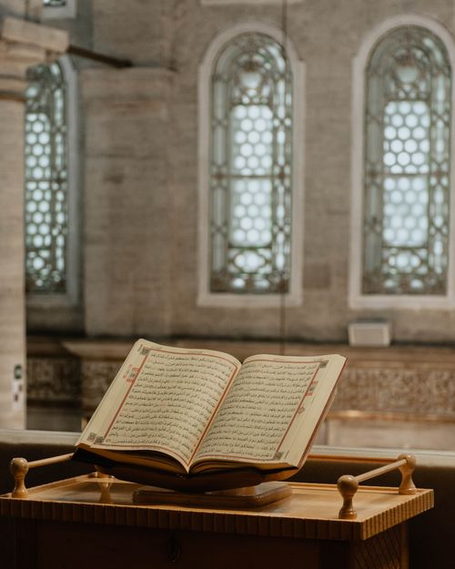 Free An open religious book on a pedestal in a historic church interior, showcasing intricate architecture. Stock Photo
