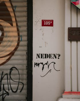 Wall with graffiti and sign, showing an urban street art scene.