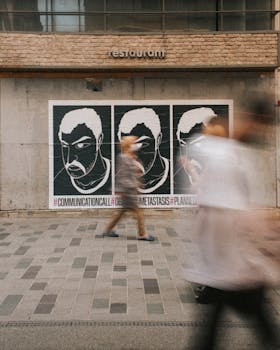 Dynamic street art scene with blurred pedestrians passing by a restaurant wall.