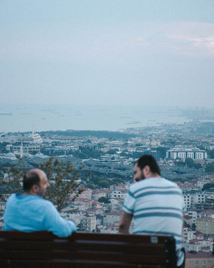 Two Men Sitting On Wooden Bench