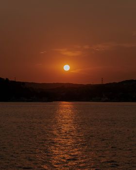 Experience serenity with a picturesque sunset casting warm hues over a tranquil lake horizon.