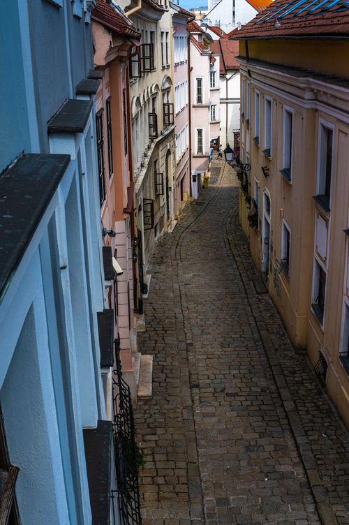 Free Explore a narrow cobblestone alley lined with colorful historic buildings in a quaint European town. Stock Photo