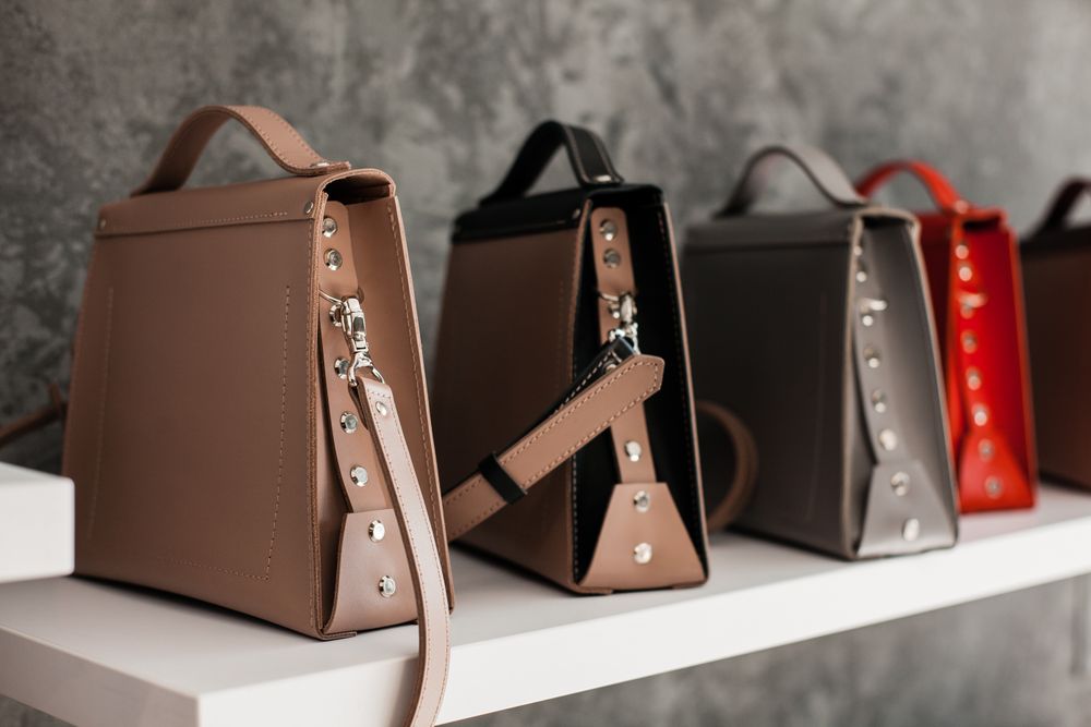 Leather bags set out along a white wooden shelf