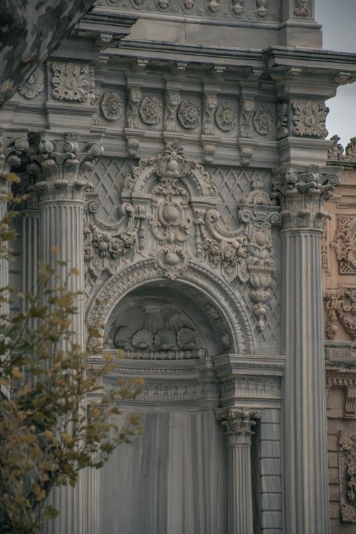 Free Close-up of an ornate architectural facade showcasing detailed stone carvings and classical columns. Stock Photo
