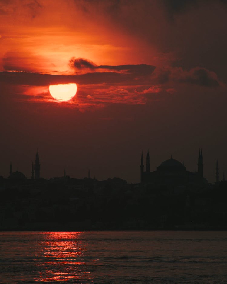 Sunset Above City Silhouette On Horizon