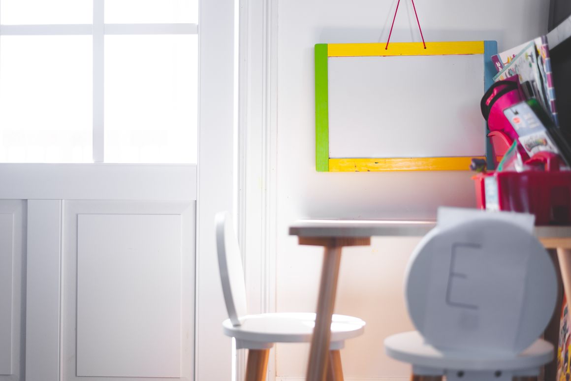 A real children's learning space with a study desk, chair, storage, and educational board