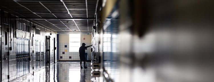 Man In Hallway Near Lockers