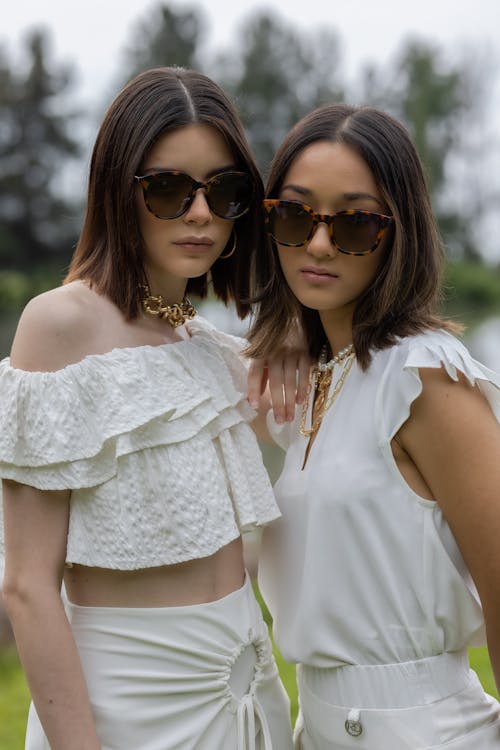 Free Two Women in White Clothes Wearing Sunglasses Stock Photo