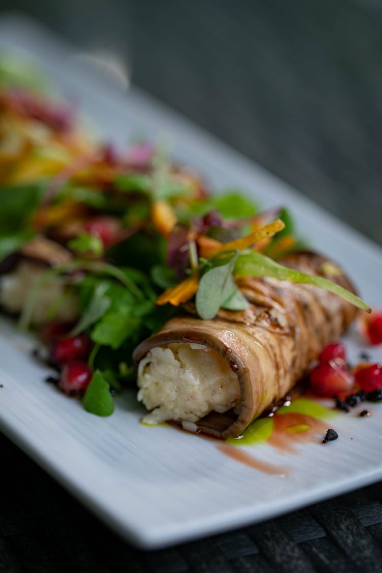 Slice Of An Eggplant Rolled And Staffed With Cheese Served On A Salad 