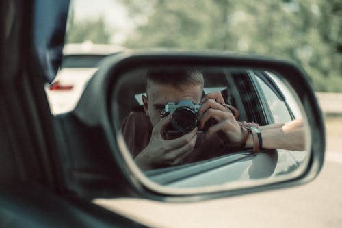 Free Mirror Reflection of Man Sitting in the Car Taking Photos  Stock Photo