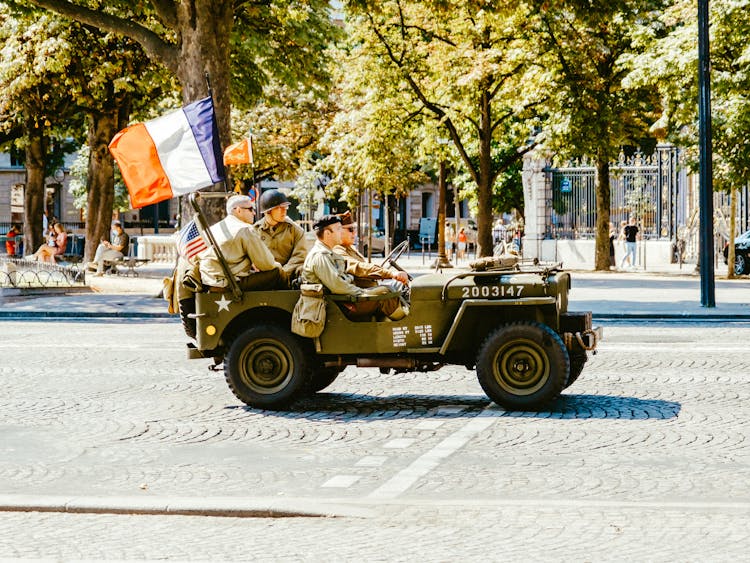 Soldiers In Car Driving City Street