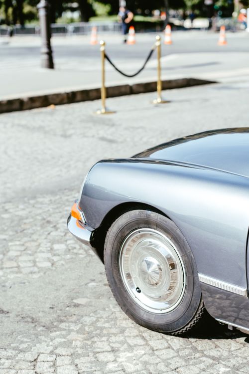 Free Detailed view of a classic Citroen parked on a cobblestone street, showcasing a shiny tire and hood. Stock Photo