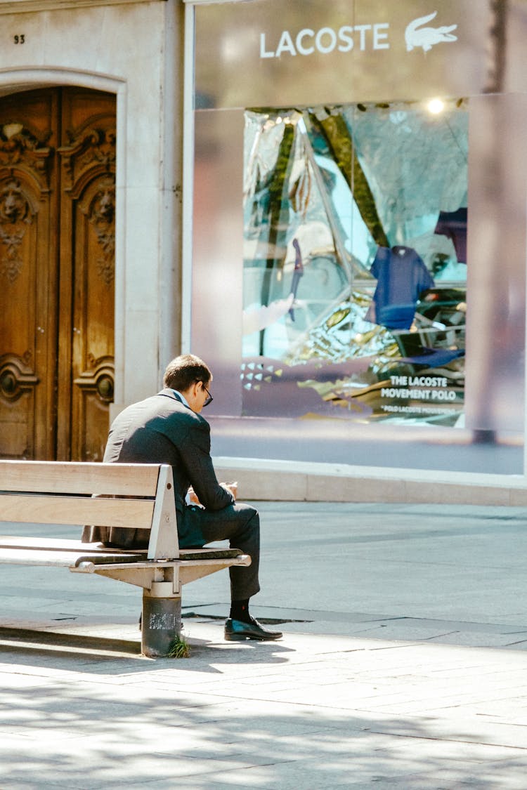 Man In Black Suit Sitting On Bench