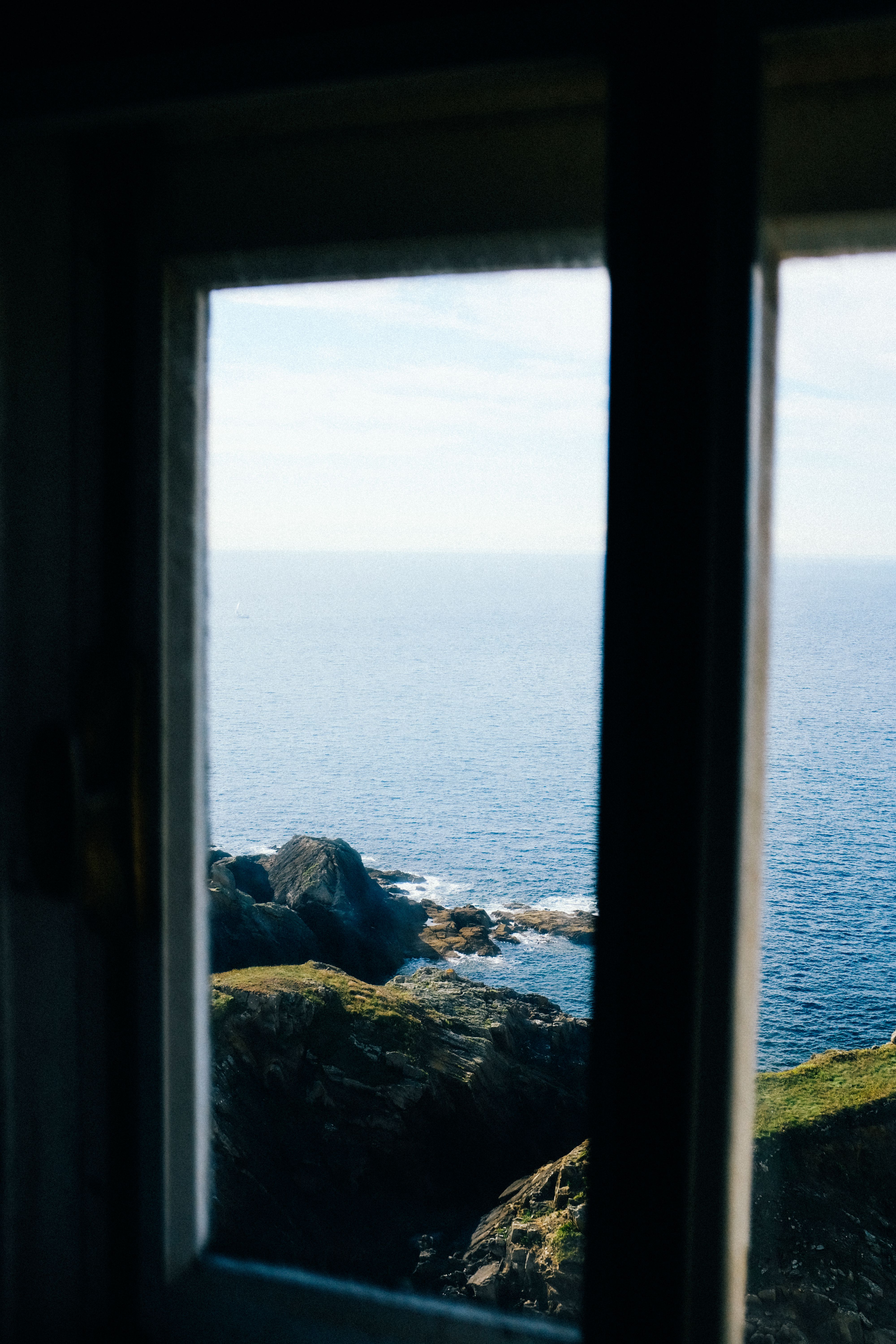 View of a Rocky Coast and a Seascape From a Window · Free Stock Photo