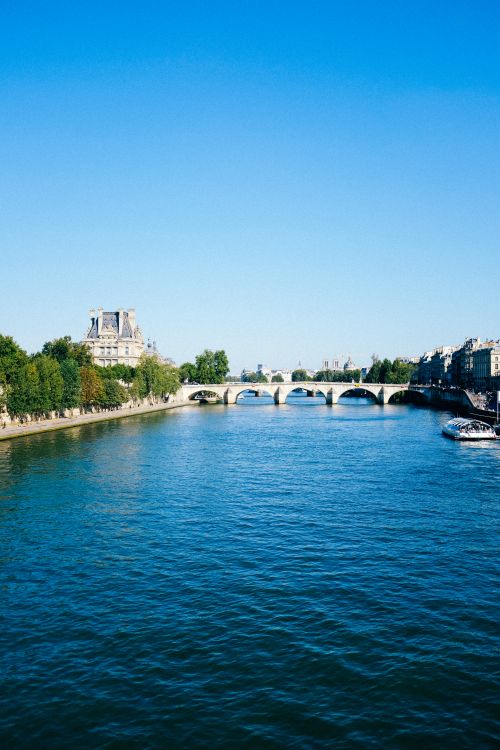 Free Captivating image of the Seine River with historic architecture and a blue sky in Paris. Stock Photo