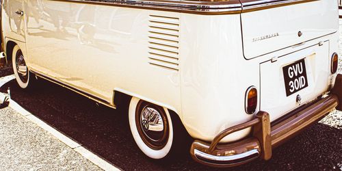 Free Classic white Volkswagen van parked on pavement. Vintage aesthetic with close-up details. Stock Photo