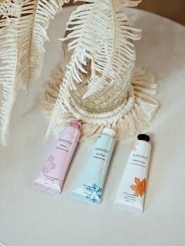 Aesthetic display of skincare tubes on a table with decorative leaves, creating a serene ambiance.