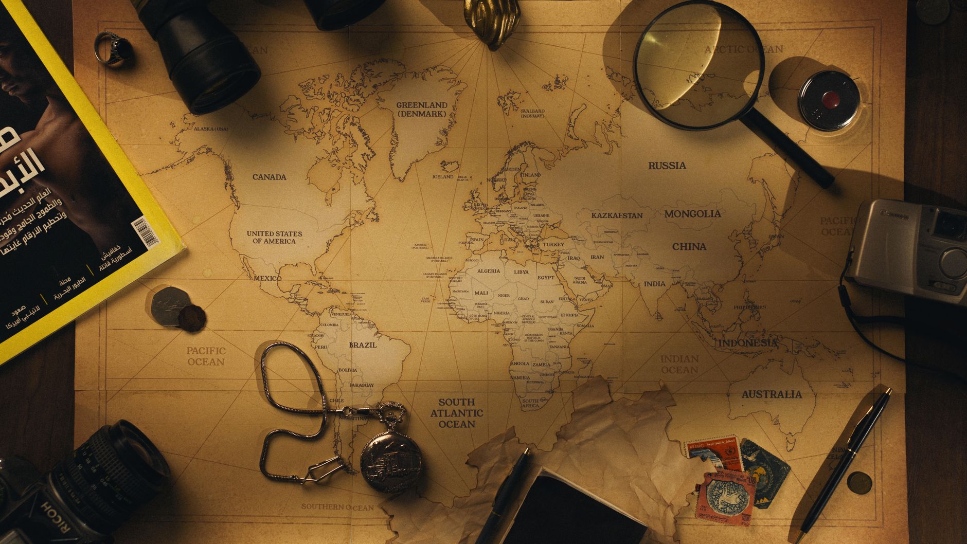 Flatlay of exploration tools and a vintage world map, capturing the essence of adventure.
