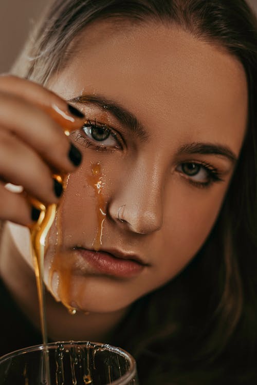 Portrait of a Woman with Brown Liquid on Her Face