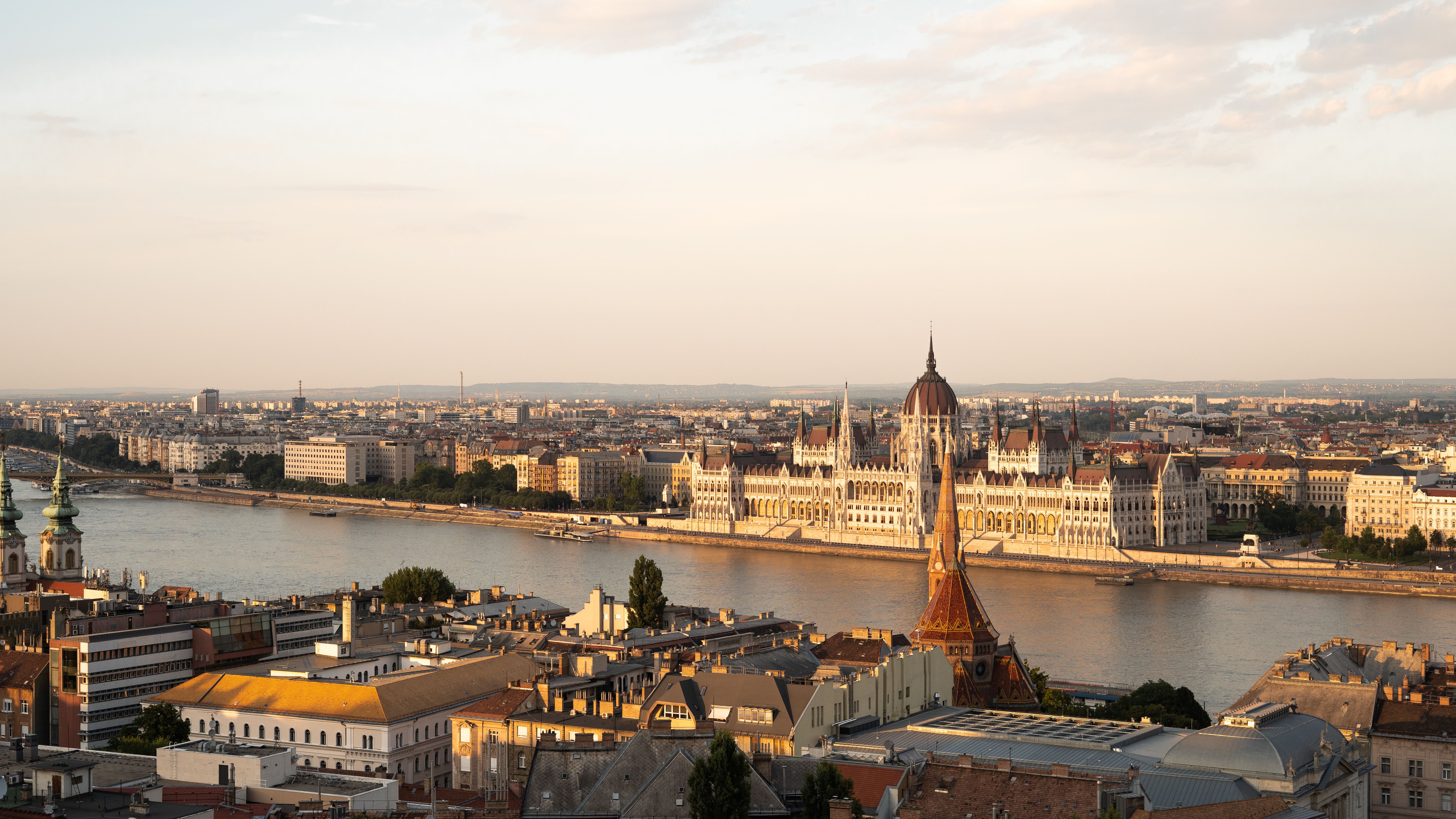 Panoramic view of Budapest skyline at sunset, showcasing the Danube River and historic buildings