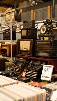 A collection of vintage radios and typewriters on display at a Budapest market.