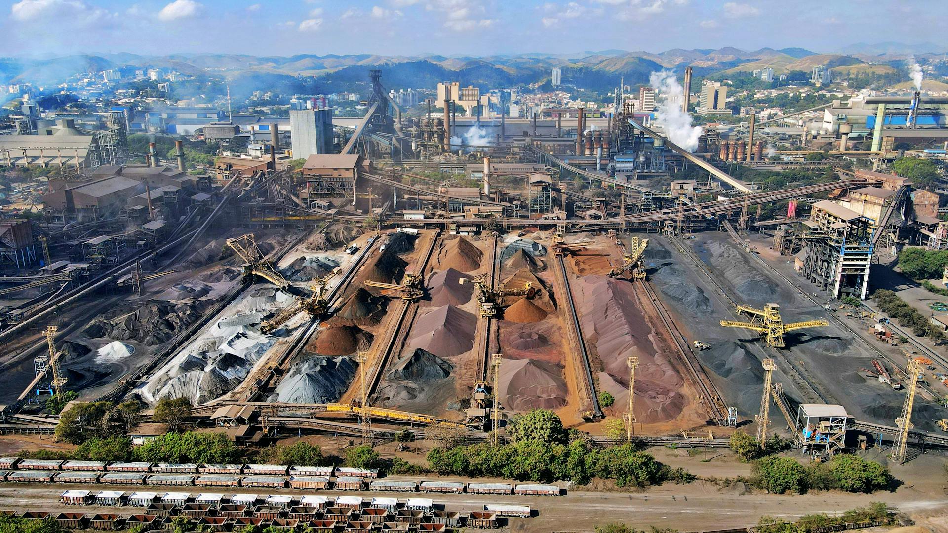 An expansive industrial mining facility with machinery and slag heaps in Brazil.