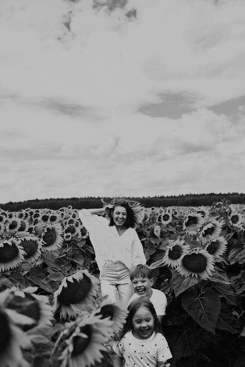 Grayscale Photo of People Standing on Field