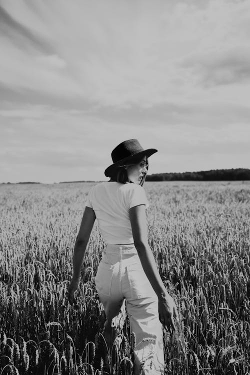 A Woman Walking in the Middle of a Cropland