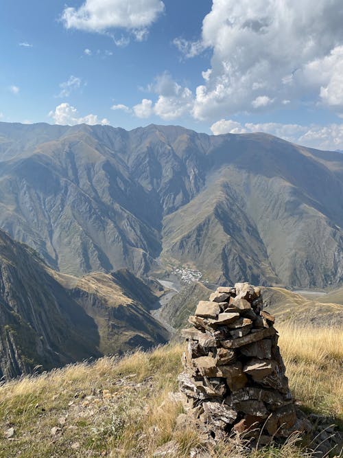 Rocks on Green Grass Field Near Mountains