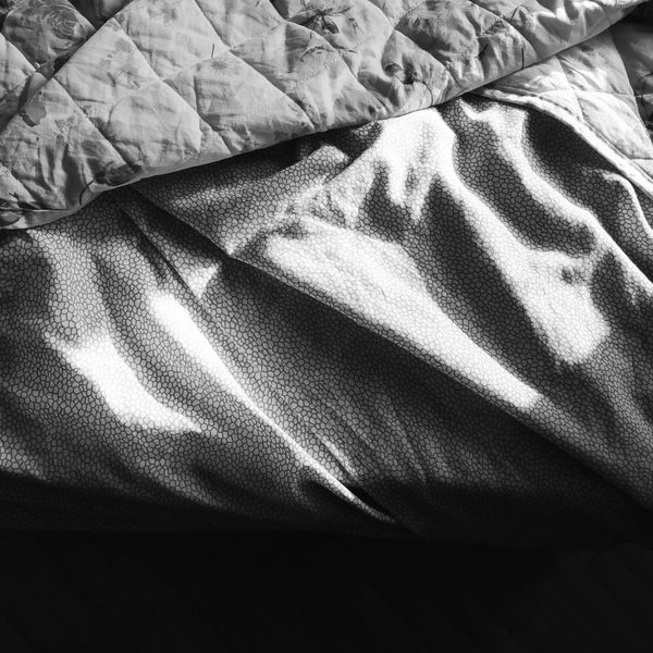Sunlight falling across textured folded bed linen, photo by Alena Tamarovskaia on Pexels