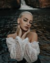 一位闭着眼睛的女性时尚肖像，以瀑布为背景，展示了时尚和美丽