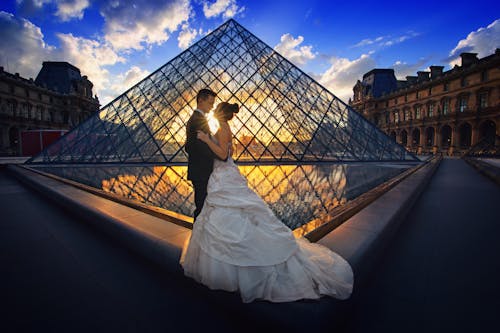 Photography of Man and Woman at the Lourve Museum during Sunset