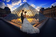 在巴黎令人惊叹的日落时分，情侣们在卢浮宫金字塔前拥抱