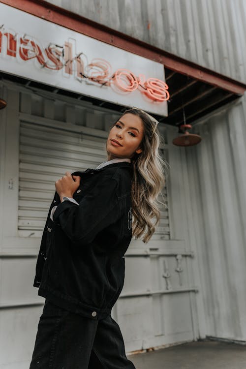 Woman in Black Coat Standing Near White Wall