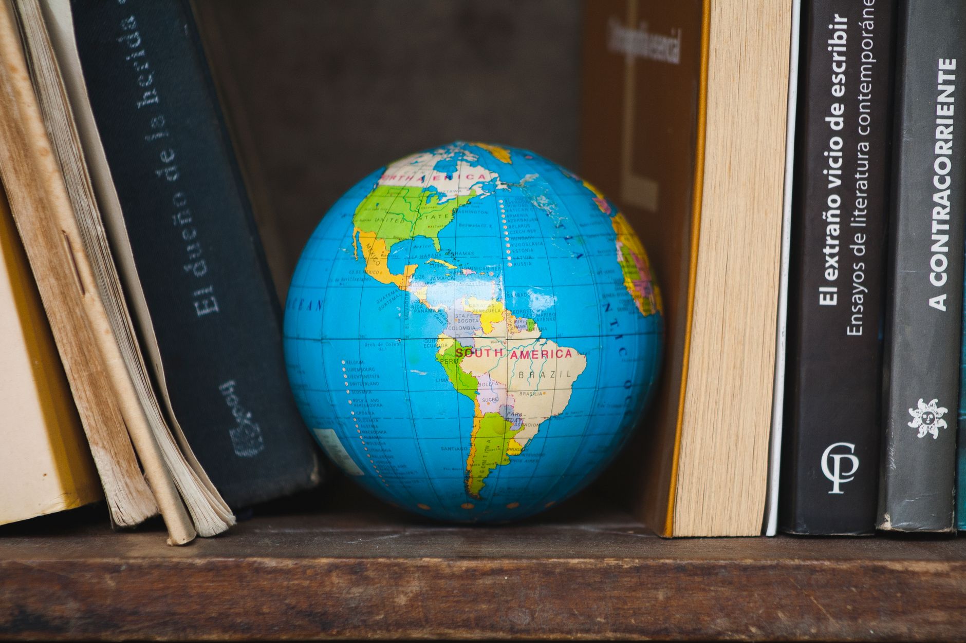 A bookshelf with books and a globe