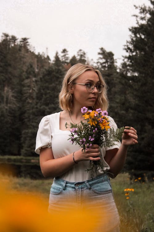 Blonde Woman with Eyeglasses Holding a Bouquet of Flowers