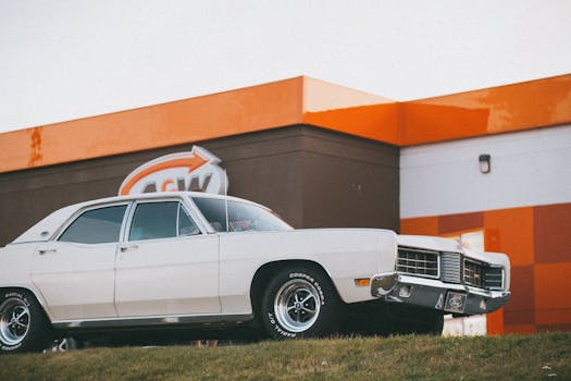 Retro white car parked outside an A&W restaurant, capturing vintage vibes.
