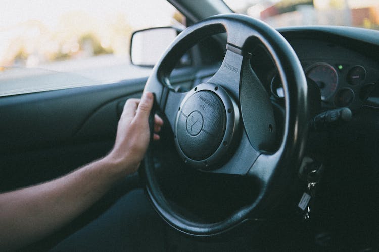 Person Holding A Black Mitsubishi Motors Steering Wheel