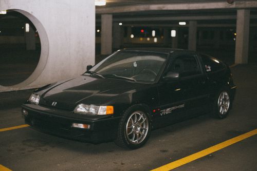 Free Vintage black Honda CR-X parked in dimly lit parking garage. Urban night setting. Stock Photo