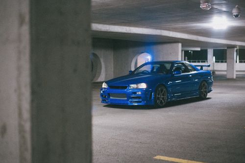 Free A classic blue Nissan Skyline GT-R parked in a dim indoor garage setting. Stock Photo