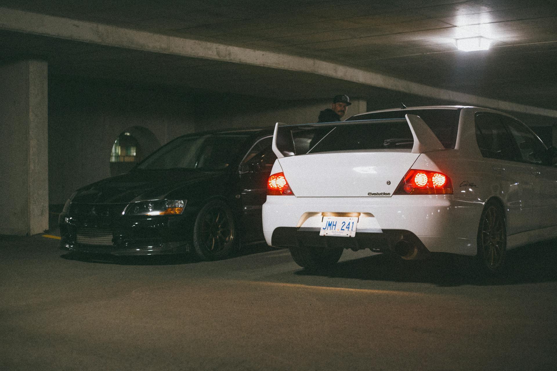 Black and white Mitsubishi cars parked in a dimly lit underground garage.