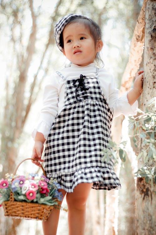 Free Girl in White Long-sleeved Dress Holding Basket of Flowers Stock Photo