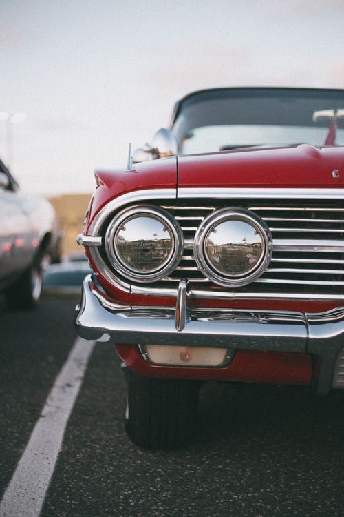Free Close-up of the front bumper and headlights of a vintage red car. Stock Photo