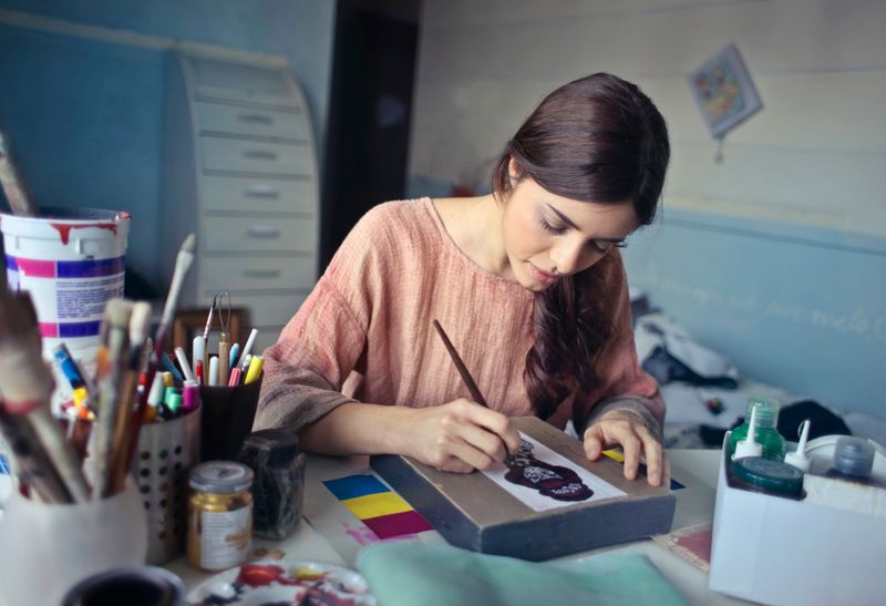 Female artist deeply engaged in painting at her creative studio workspace