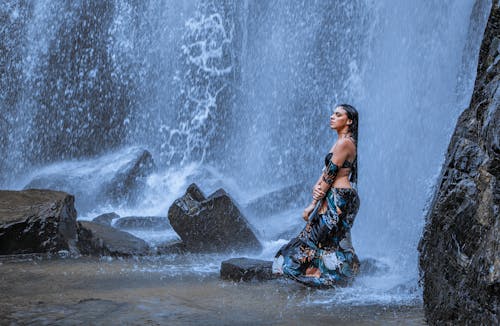 Woman in Tube Top Standing Under a Waterfall