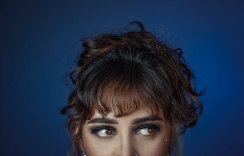 Woman With Blonde Hair and Brown Eyes in Blue Background 