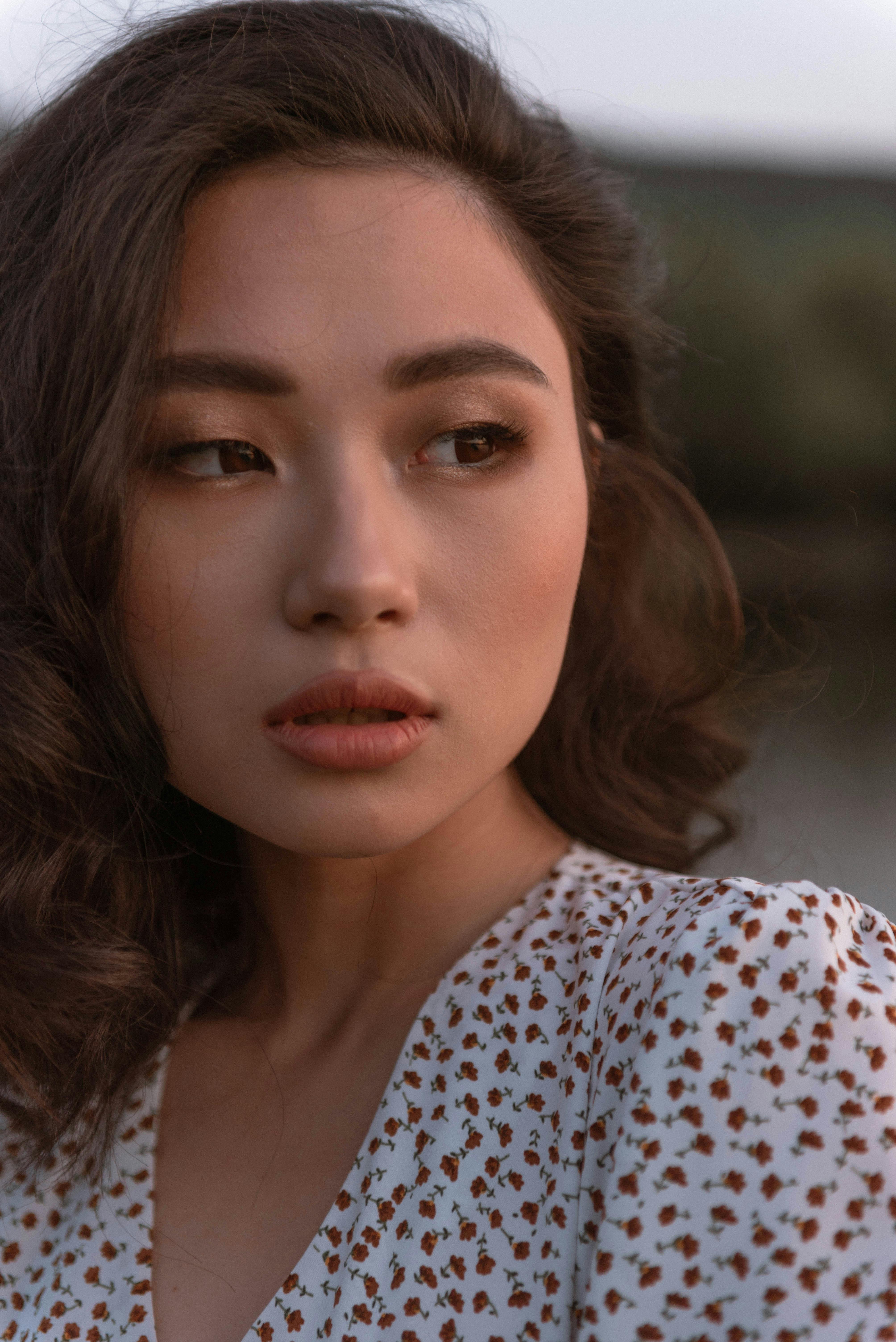 Elegant portrait of a woman in soft natural light outdoors, highlighting her beauty.