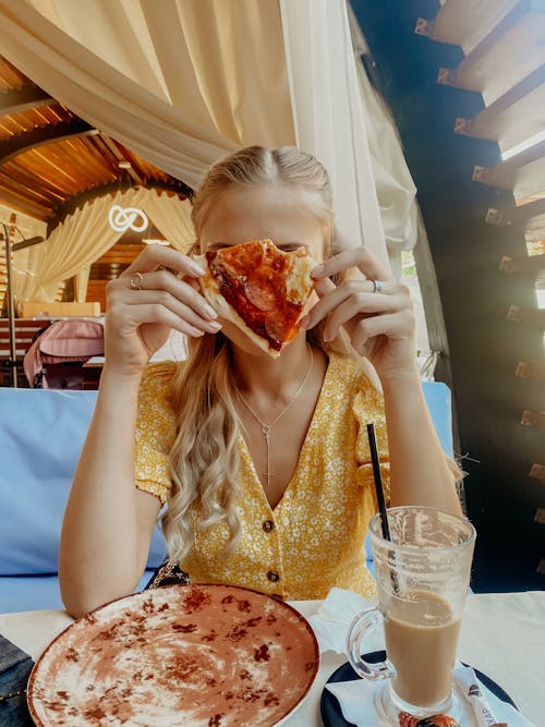 Free Woman in Yellow Dress Eating Pizza Stock Photo