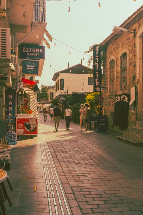 Free A vibrant sunlit street with market signs and people walking in Turkey. Stock Photo
