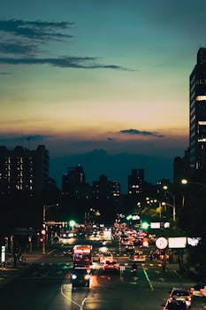 A vibrant city scene at dusk with illuminating streetlights and bustling traffic showcasing urban life.